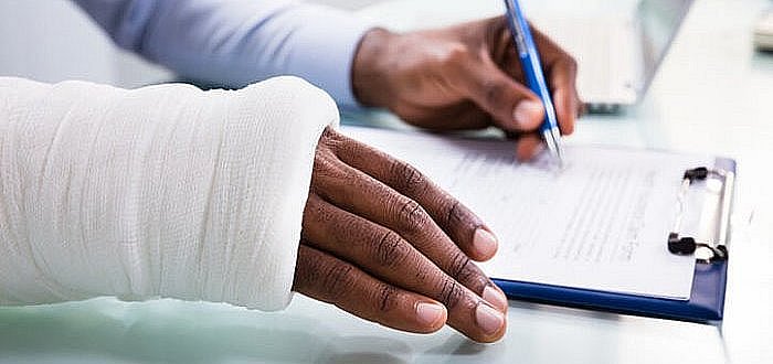 Injured Man Filling Insurance Claim Form